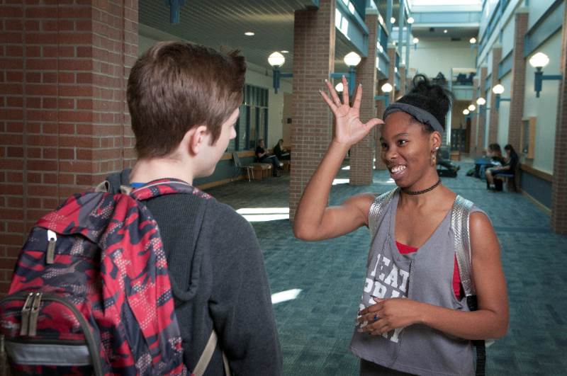Students practicing ASL in hallway