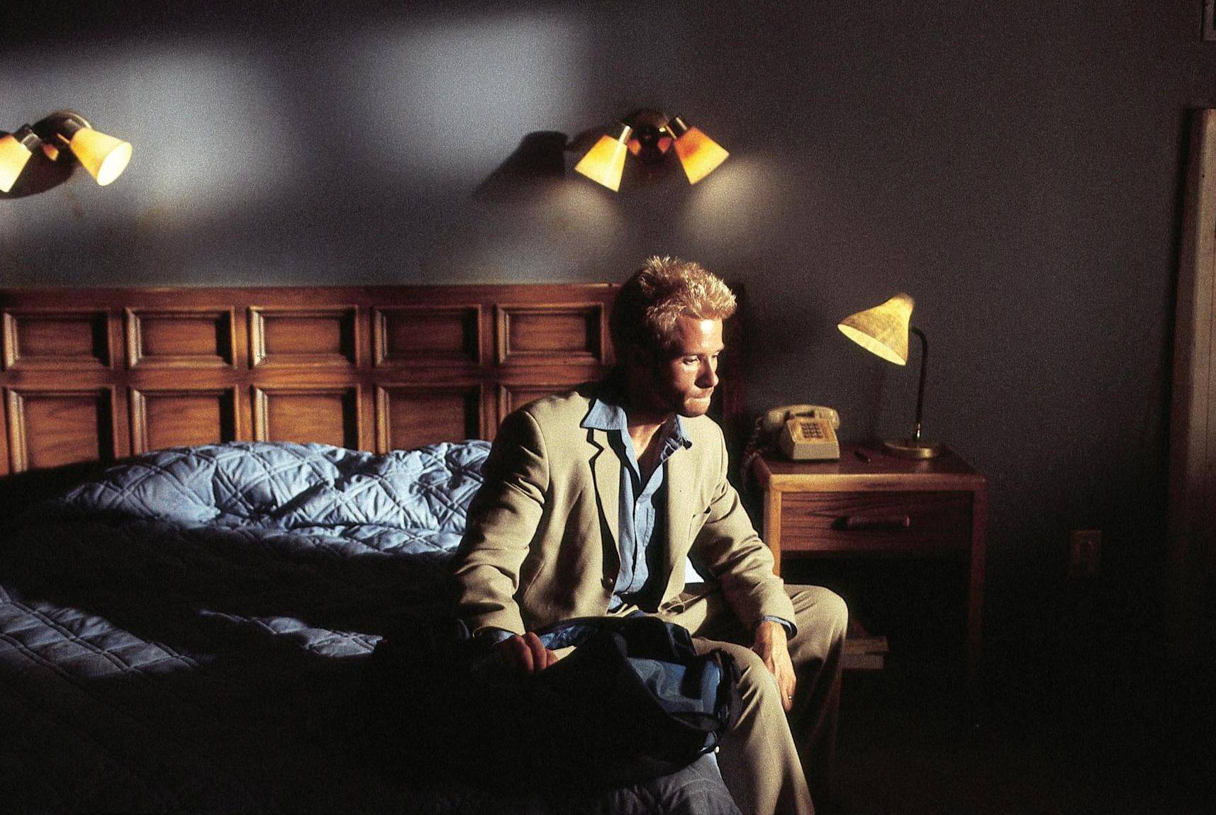 man sitting on bed