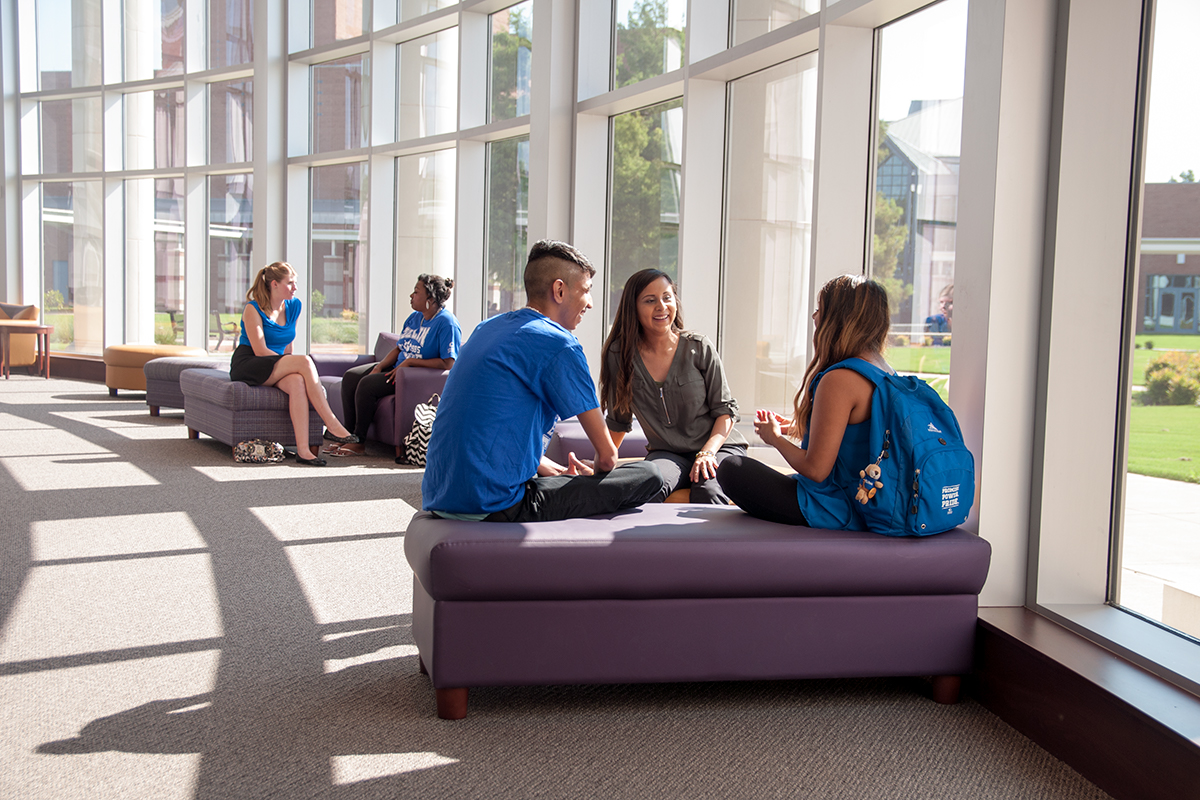 Students sit in the Plano Campus library and work collaboratively