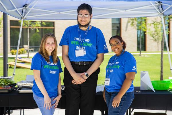 3 students smiling at event