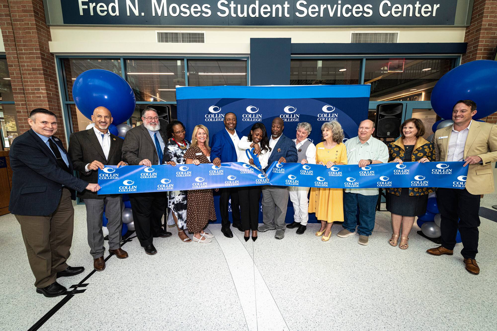 Family members of Fred N. Moses join Collin College Board of Trustees members and college leadership for the ribbon-cutting in front of the newly named Fred N. Moses Student Services Center.