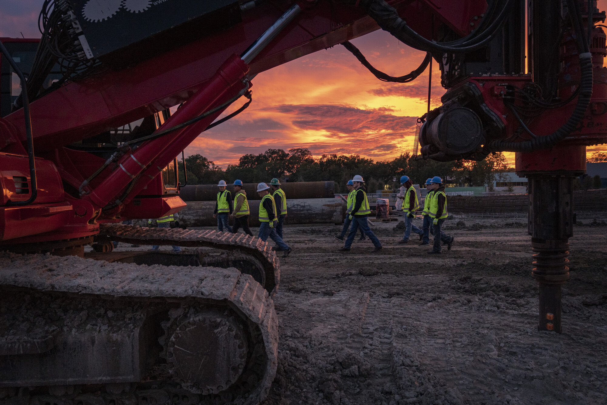construction workers walking with a sunset background 